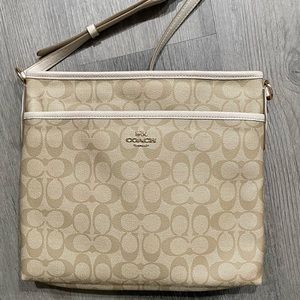 Light tan and white leather coach crossbody bag.